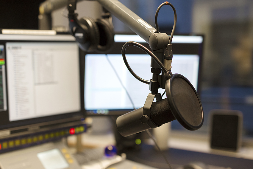 Studio microphone in front of radio station broadcasting equipment
